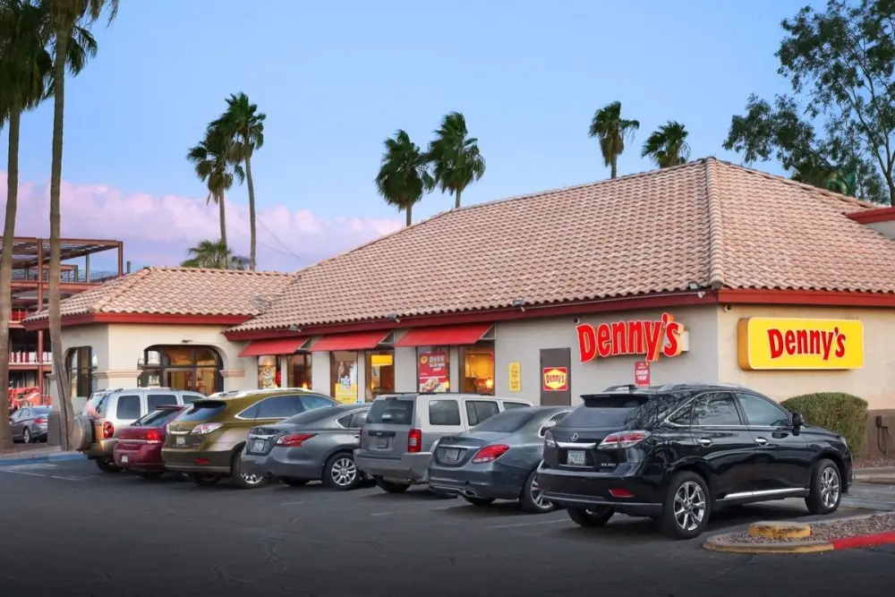 Exterior of a Denny's restaurant building at dusk, owned by Brett Tanner