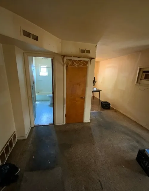 Worn interior of a unit with stained carpet and aging finishes